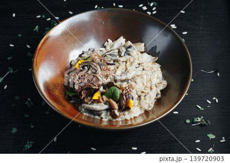 Savory mushroom risotto garnished with herbs and sesame seeds Savory mushroom risotto garnished with herbs and sesame seeds 139720903