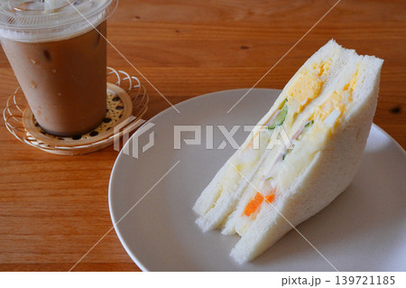 たまごサンドとアイスコーヒーの軽食ランチカフェ風テーブル写真 たまごサンドとアイスコーヒーの軽食ランチカフェ風テーブル写真 139721185