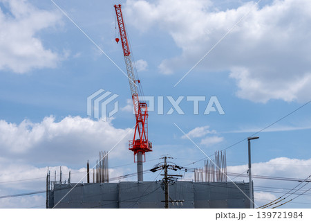 青空と雲を背景にした赤白の建設クレーン 青空と雲を背景にした赤白の建設クレーン 139721984