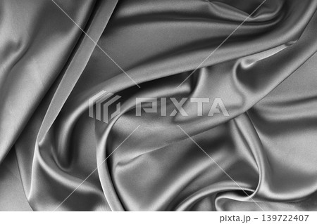 Crumpled, wrinkled gray colored glossy silk satin texture. Shiny fabric cloth with wave folds Crumpled, wrinkled gray colored glossy silk satin texture. Shiny fabric cloth with wave folds 139722407
