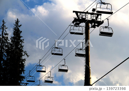 Cable car support pillar with empty chairs on cables 139723398