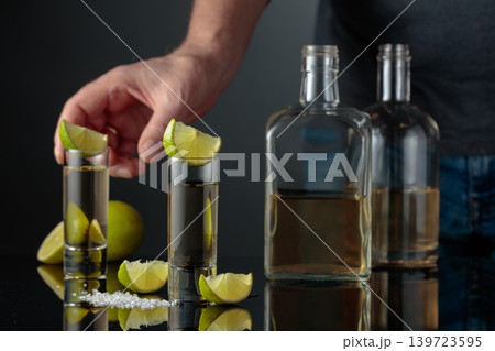 Gold tequila with sea salt and lime slices. 139723595
