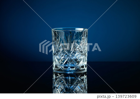 Glass of vodka on a black reflective background, with blue lighting. Glass of vodka on a black reflective background, with blue lighting. 139723609