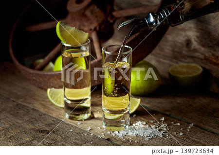 Tequila with salt and lime slices. 139723634