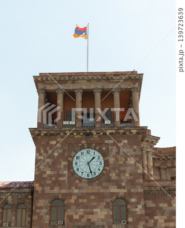 Government of Armenia, Yerevan. A historic stone clock tower under Armenian flag 139723639