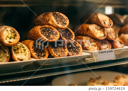 Sweet cannoli stuffed with chocolate and pistachio cream in a bakery. Sweet cannoli stuffed with chocolate and pistachio cream in a bakery. 139724619