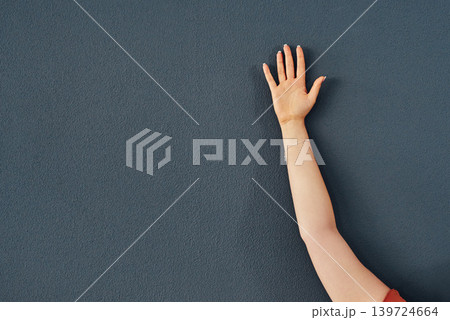 Hand, raise and question asking for education on grey wall background or training, learning or mockup space. Person, fingers and answer response with information or vote agreement, opinion or meeting 139724664