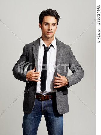 Fashion, serious and portrait of man in a studio with formal, elegant and classy outfit with blazer. Confident, handsome and young model from Canada with attractive style isolated by gray background. Fashion, serious and portrait of man in a studio with formal, elegant and classy outfit with blazer. Confident, handsome and young model from Canada with attractive style isolated by gray background. 139724669