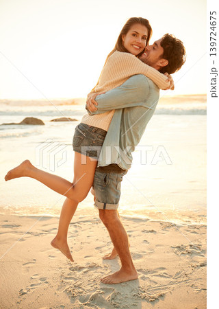 Love, hug and portrait of couple at beach on vacation, adventure or holiday for valentines day. Sunset, happy and man carry, embrace and bond with woman by ocean for weekend trip on romantic date. 139724675
