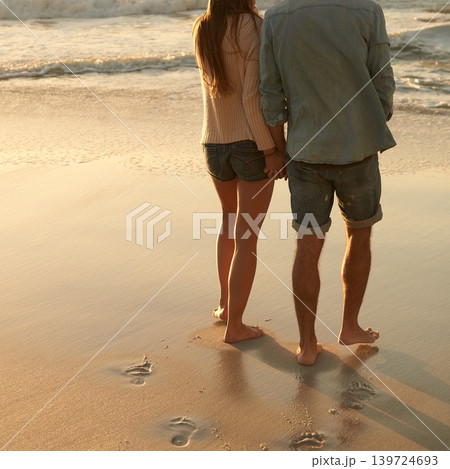 Beach, sunset and couple holding hands with love, support and relationship security on summer holiday in Portugal. Mockup space, sand and back of partner, soulmate or people on evening walk together Beach, sunset and couple holding hands with love, support and relationship security on summer holiday in Portugal. Mockup space, sand and back of partner, soulmate or people on evening walk together 139724693