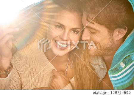 Couple, beach and cover with towel for protection from cold in environment for weather, sun or wind. Man, woman and happy shelter for outdoor adventure or relax vacation for bonding, marriage or trip Couple, beach and cover with towel for protection from cold in environment for weather, sun or wind. Man, woman and happy shelter for outdoor adventure or relax vacation for bonding, marriage or trip 139724699