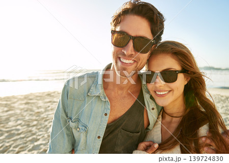 Couple, sea and sunglasses with embrace, smile or care for nature, eye protection or holiday in summer. Man, woman and hug with glasses at beach for sun, happy and love by ocean on tropical vacation 139724830