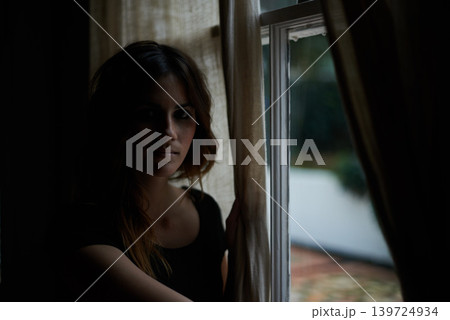 Woman, portrait and relax by window at night in dark room in stress, anxiety or mental health and lonely at home. Young female person sitting by glass at house with insomnia in neighborhood apartment Woman, portrait and relax by window at night in dark room in stress, anxiety or mental health and lonely at home. Young female person sitting by glass at house with insomnia in neighborhood apartment 139724934