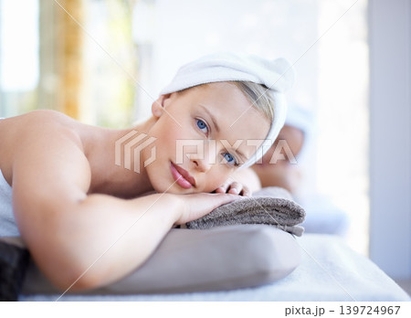 Woman, relax and portrait lying on table in spa for skincare, beauty and luxury treatment for wellness. People, rest and face of calm person on bed in hotel for massage or dermatology care for body 139724967
