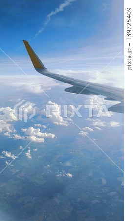 Blue clear sky. Airplane wing above cumulus clouds 139725409