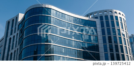 Glass and steel modern building facade on blue sky 139725412
