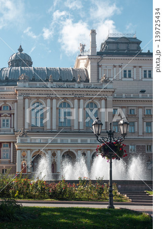 Sunlit opera house behind fountain with blue sky 139725434