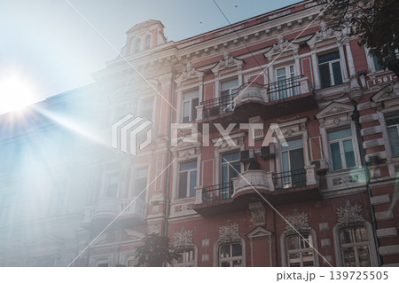 Sunlit Red Ornate Building Facade with Balconies 139725505