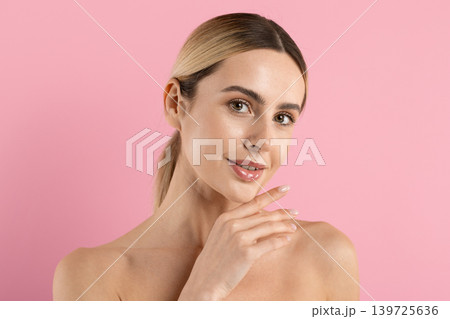 Attractive young caucasian woman posing with hand under chin and glowing skin Attractive young caucasian woman posing with hand under chin and glowing skin 139725636