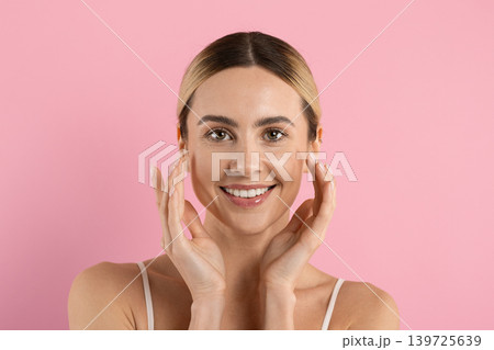 Natural beauty. Happy woman touching her cheeks with both hands and smiling Natural beauty. Happy woman touching her cheeks with both hands and smiling 139725639