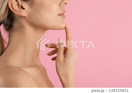 Side profile of young woman touching her chin with one finger 139725651