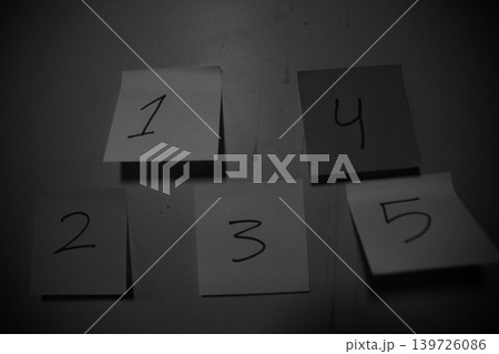 Black and white image of five numbered sticky notes on a wall planning Black and white image of five numbered sticky notes on a wall planning 139726086
