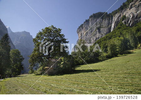 Lauterbrunnen valley landscape with traditional swiss cabin and waterfalls Lauterbrunnen valley landscape with traditional swiss cabin and waterfalls 139726528