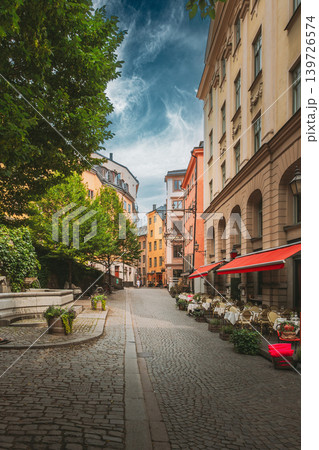 Wide cobblestone lane with trees and cafe awning in Gamla Stan, Stockholm 139726574