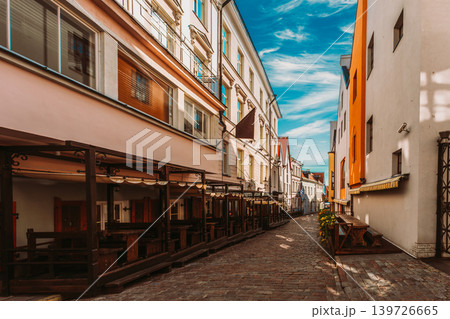 Empty Cobblestone Street with Outdoor Cafe Terraces in Tallinn Empty Cobblestone Street with Outdoor Cafe Terraces in Tallinn 139726665