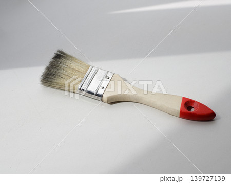 Clean wooden bristle brush on a light gray furniture panel. DIY home improvement and repair concept. 139727139