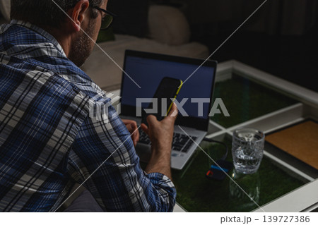 Freelancer checking smartphone during online work Freelancer checking smartphone during online work 139727386