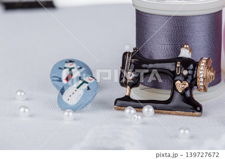 still life of a skein of thread for sewing, needles, buttons, sewing machine on a white background still life of a skein of thread for sewing, needles, buttons, sewing machine on a white background 139727672