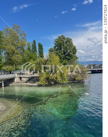 Scenic view of a tranquil lake with clear turquoise water, surrounded by Scenic view of a tranquil lake with clear turquoise water, surrounded by 139727814