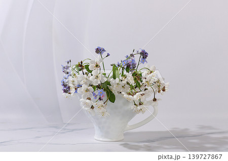 Abstract floral arrangement and banner for the screen. Still life with beautiful spring cherry blossom branches in a vase against an elegant background,floral holiday card with a summer greeting Abstract floral arrangement and banner for the screen. Still life with beautiful spring cherry blossom branches in a vase against an elegant background,floral holiday card with a summer greeting 139727867