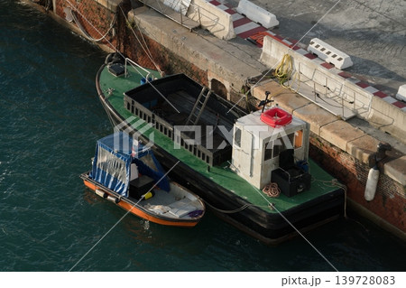 Service barge moored on Venice canal beside small boat, Venice, Italy. 139728083