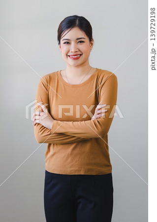 Confident asian woman with friendly smile stands with arms crossed isolated on white background. Confident asian woman with friendly smile stands with arms crossed isolated on white background. 139729198