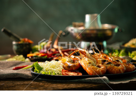 Close up grilled river prawns served with fresh vegetables, spicy seafood sauce and Thai herbs on rustic table, authentic Thai seafood cuisine and premium restaurant dining concept Close up grilled river prawns served with fresh vegetables, spicy seafood sauce and Thai herbs on rustic table, authentic Thai seafood cuisine and premium restaurant dining concept 139729321