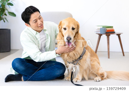 ペット ゴールデンレトリーバー リビングで寛ぐ犬と男性 ペット ゴールデンレトリーバー リビングで寛ぐ犬と男性 139729409