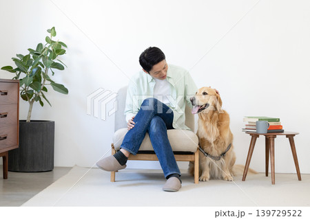 ペット ゴールデンレトリーバー リビングで寛ぐ犬と男性 ペット ゴールデンレトリーバー リビングで寛ぐ犬と男性 139729522
