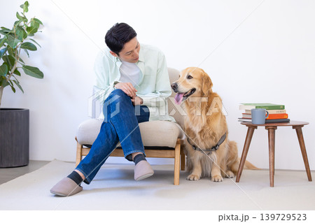 ペット ゴールデンレトリーバー リビングで寛ぐ犬と男性 ペット ゴールデンレトリーバー リビングで寛ぐ犬と男性 139729523