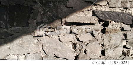 Ancient natural stone wall texture with dramatic lighting. Ancient natural stone wall texture with dramatic lighting. 139730226