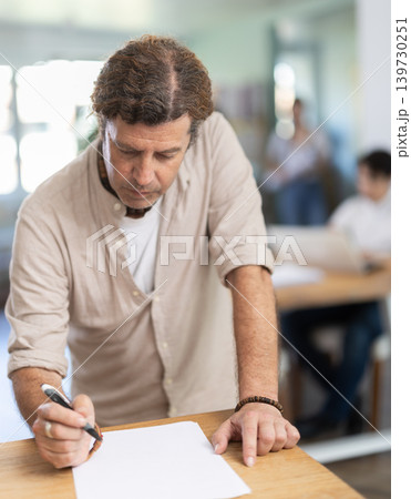 Portrait of manager reading and signing documents in modern office 139730251