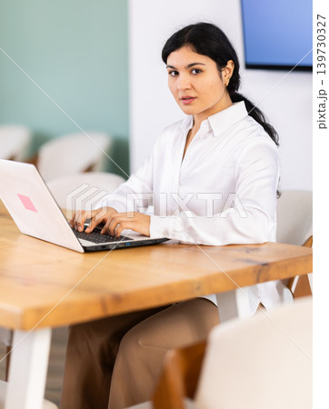 Female works on laptop in room Female works on laptop in room 139730327