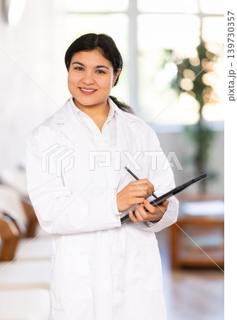 Portrait of friendly female medical receptionist with tablet Portrait of friendly female medical receptionist with tablet 139730357