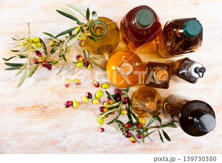 Different bottles with olive oil and olive branches Different bottles with olive oil and olive branches 139730380