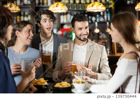 Group of friends at bar talking and drinking beer Group of friends at bar talking and drinking beer 139730444