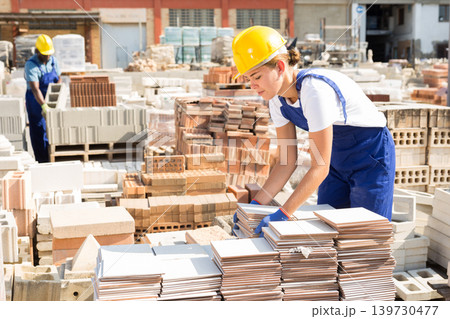 Female worker carrying ceramic tiles at warehouse Female worker carrying ceramic tiles at warehouse 139730477