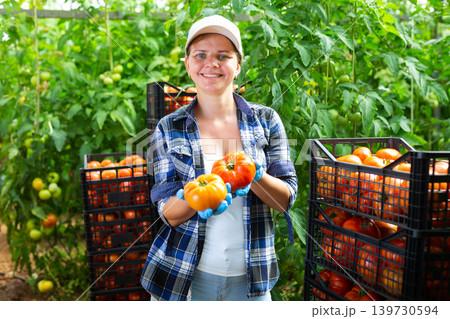 Portrait of cheerful woman farmer with tomato crop Portrait of cheerful woman farmer with tomato crop 139730594