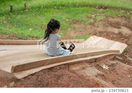 happy preschool child girl sliding and playing at playground 139730621