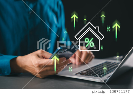 Property investment online concept displays real estate management while investor handles finance using smartphone plus laptop, highlighting rising interest rates amid market growth trends Property investment online concept displays real estate management while investor handles finance using smartphone plus laptop, highlighting rising interest rates amid market growth trends 139731177